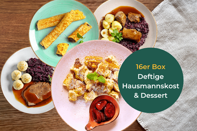 Hausmannskost-Box + Dessert-Box von Hofmanns auf einem Holztisch mit grünem beschreibenden Etikett.