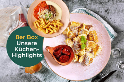 Unsere Küchenhighlights von Hofmanns Shop auf grauer Fläche: Kaiserschmarrn, Pommes mit Soße, Kirschen & Gabel.