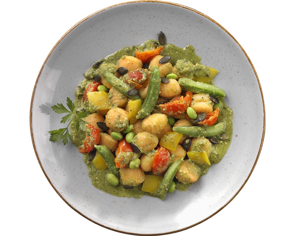 Ein Teller Süßkartoffel-Gnocchi mit Erbsenpesto von Hofmanns Shop, dazu gemischtes Gemüse und garniert mit Petersilie.